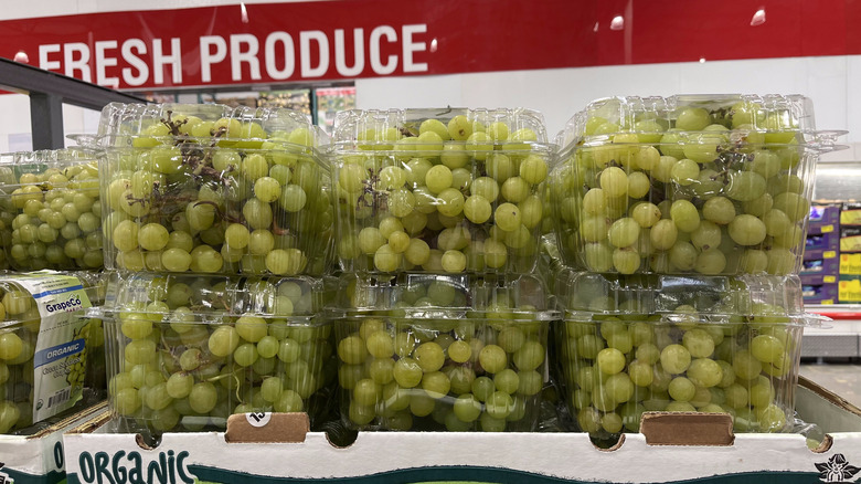 Un présentoir Costco avec des paquets de raisins verts