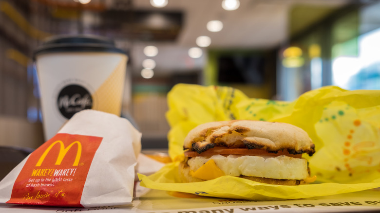Un Egg McMuffin est sur un plateau à côté des pommes de terre rissolées de McDonald's et du café