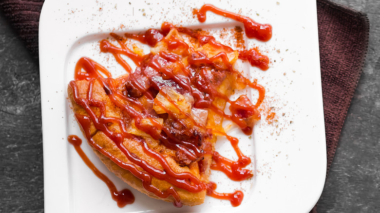 Tranche de pizza avec garniture arrosée de ketchup