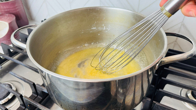 Grand fouet combinant la farine et le beurre dans une casserole