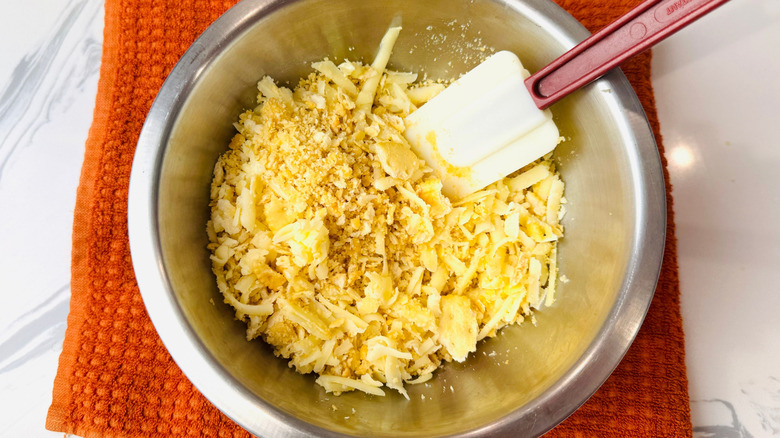 Craquelins écrasés et fromage râpé dans un bol