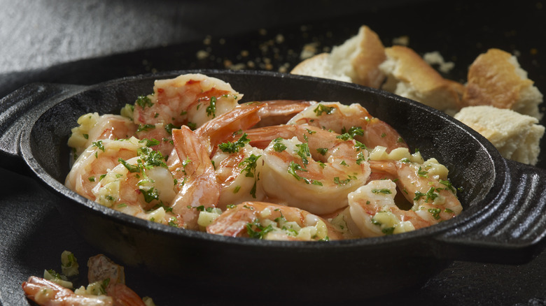 Langoustines aux crevettes à l'ail dans une poêle en fonte avec du pain croustillant