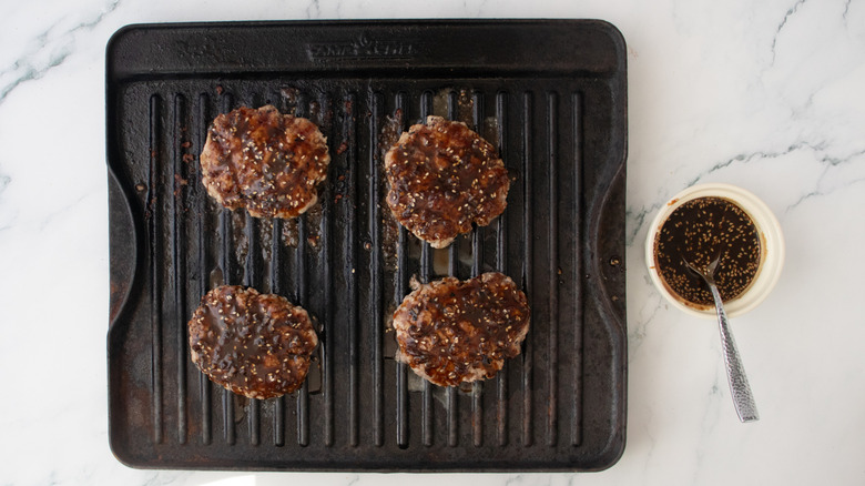 Galettes de porc grillées sur une poêle à griller glacées dans une sauce noire
