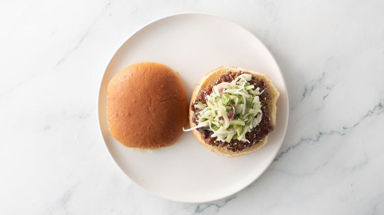 Burger de porc ouvert avec salade de chou sur assiette