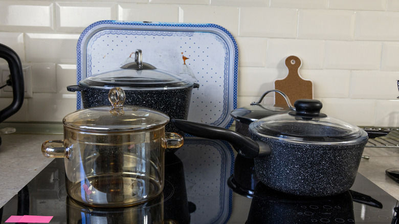 Différents types d'ustensiles de cuisine sur une table de cuisson à induction