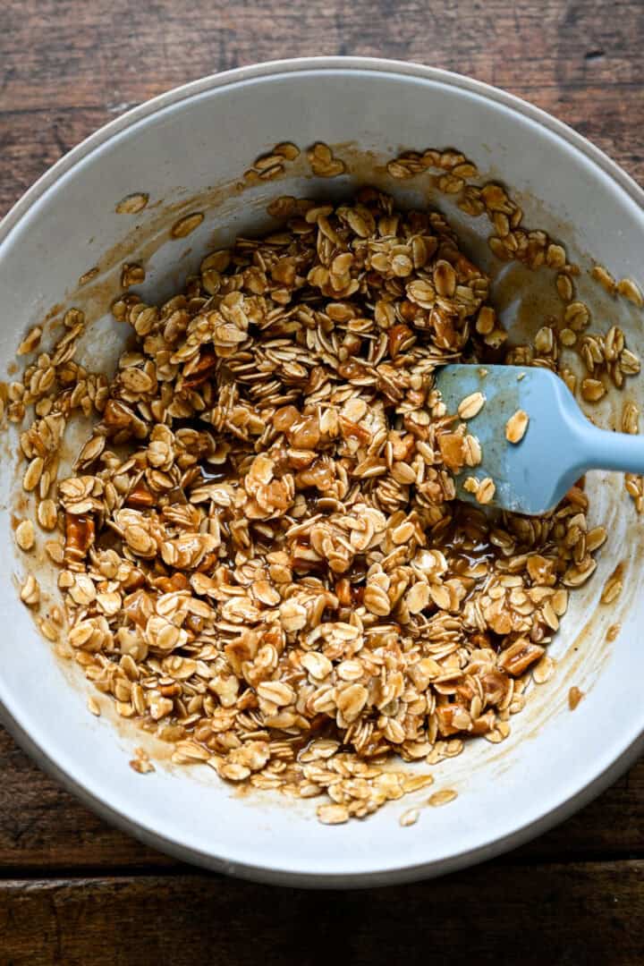 Mélange d'avoine mélangé avec le beurre et le sirop jusqu'à ce qu'il soit collant et agglutiné.