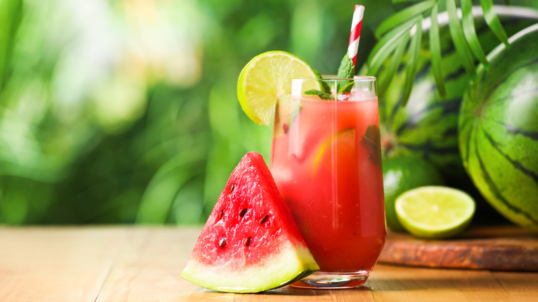 Tranche de pastèque à côté d'un verre de limonade à la menthe et à la pastèque