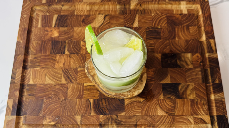 Cocktail Caipirinha dans un verre à whisky avec une tranche de citron vert