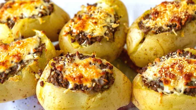Gros plan de pommes de terre au four remplies de bœuf haché et garnies de fromage fondu