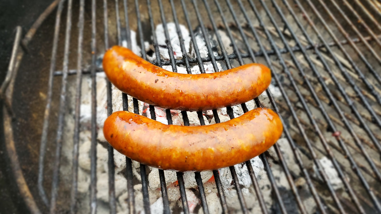 Deux saucisses juteuses sur un gril au charbon de bois