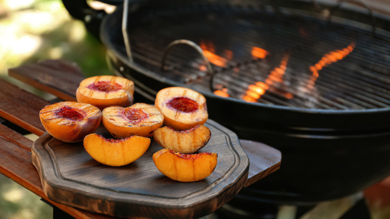 Pêches grillées sur une planche de bois.