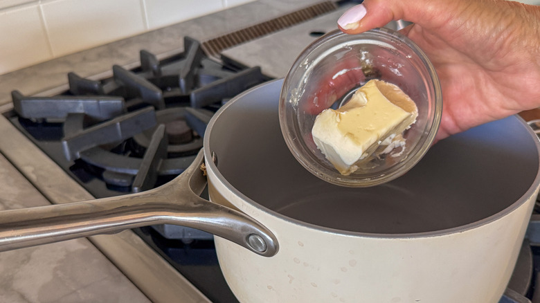 main ajoutant du beurre au pot