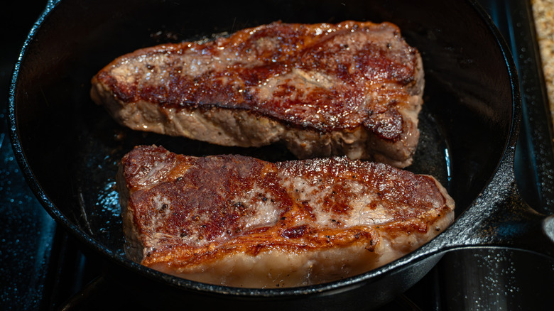 Deux steaks à croûte brune dans une poêle