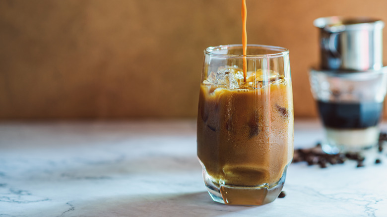 Du café vietnamien glacé est versé dans un verre.