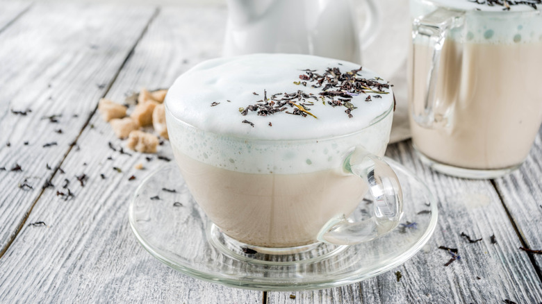 Une tasse de latte de brouillard de Londres avec des feuilles d'Earl Grey éparpillées autour