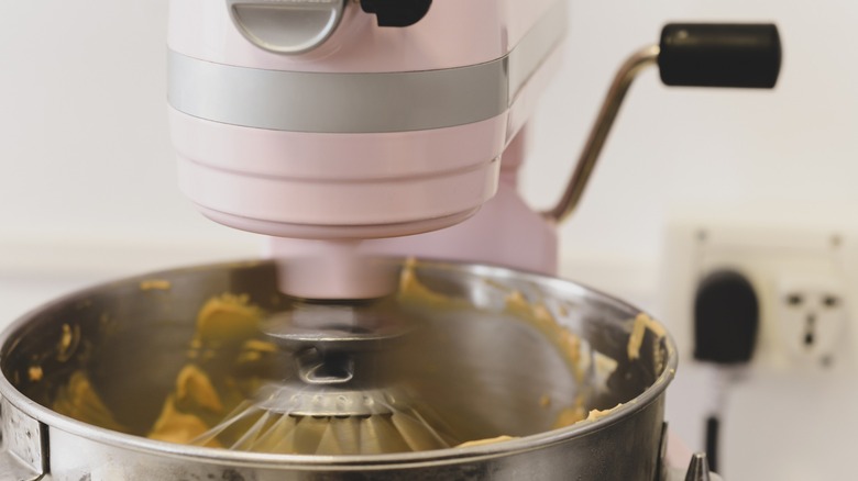 Le batteur sur socle KitchenAid rose fouette à pleine vitesse.