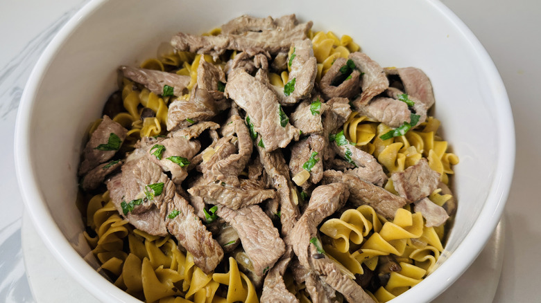 Nouilles aux œufs et lanières de steak dans un bol