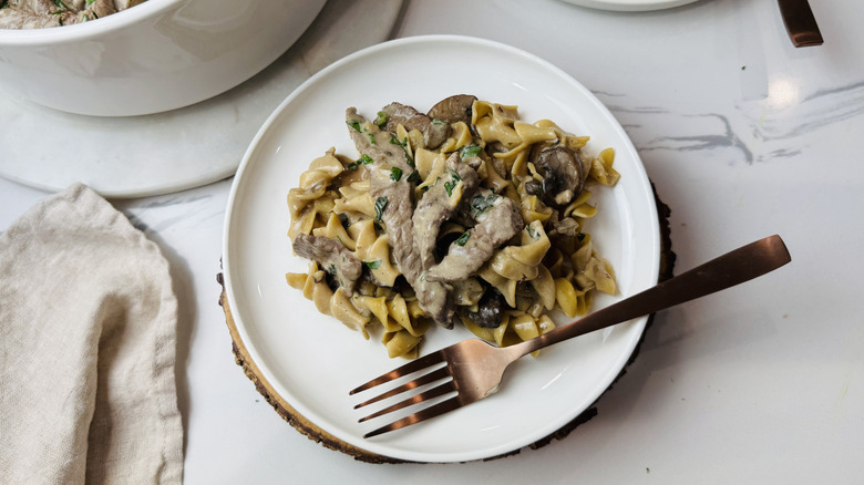Boeuf stroganoff servant sur une assiette avec une fourchette