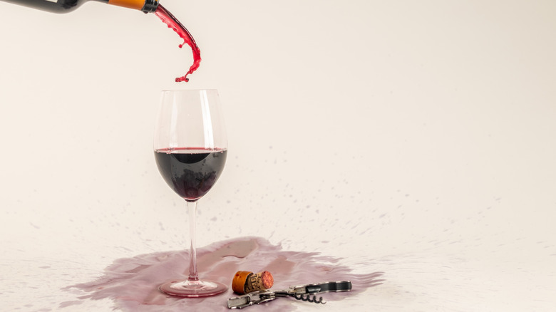 Verser de manière désordonnée le malbec Mendoza dans un verre à côté du tire-bouchon et du bouchon