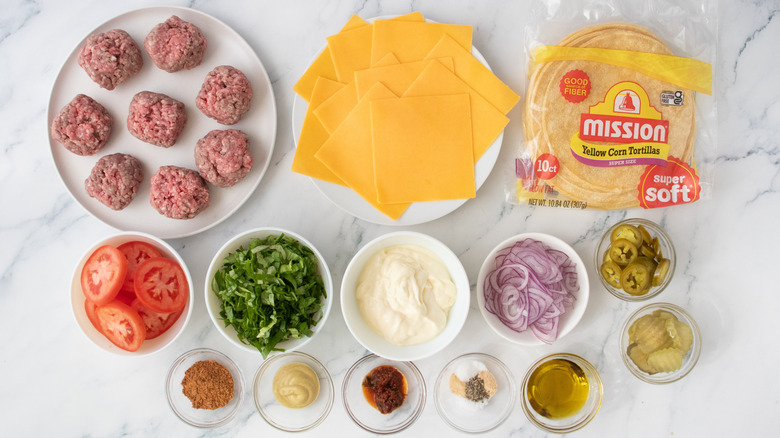 Écraser les ingrédients des tacos burger sur le comptoir