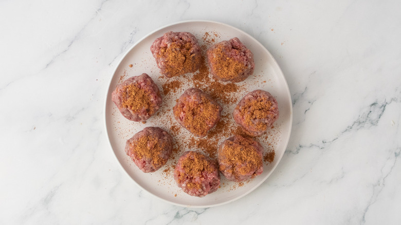 Une assiette remplie de petites portions de bœuf haché saupoudré d'assaisonnement pour tacos