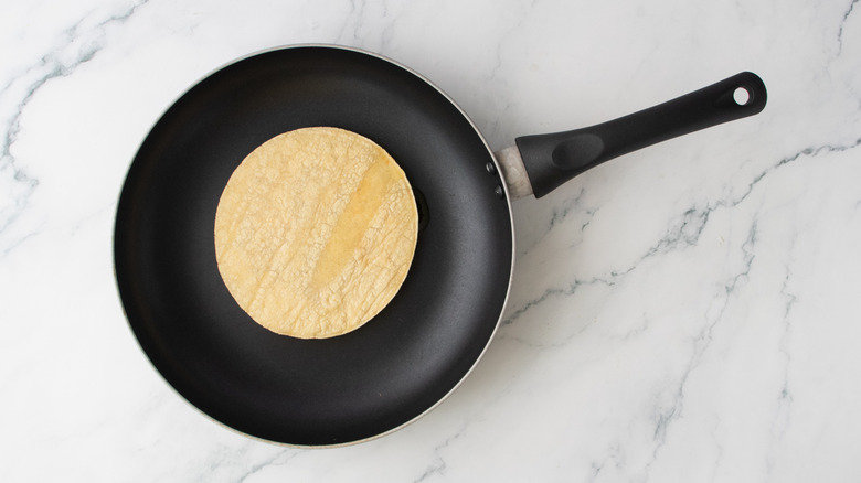 Une tortilla de maïs dans une poêle antiadhésive