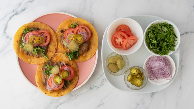 Une assiette remplie de tacos burger garnis d'ingrédients frais et marinés