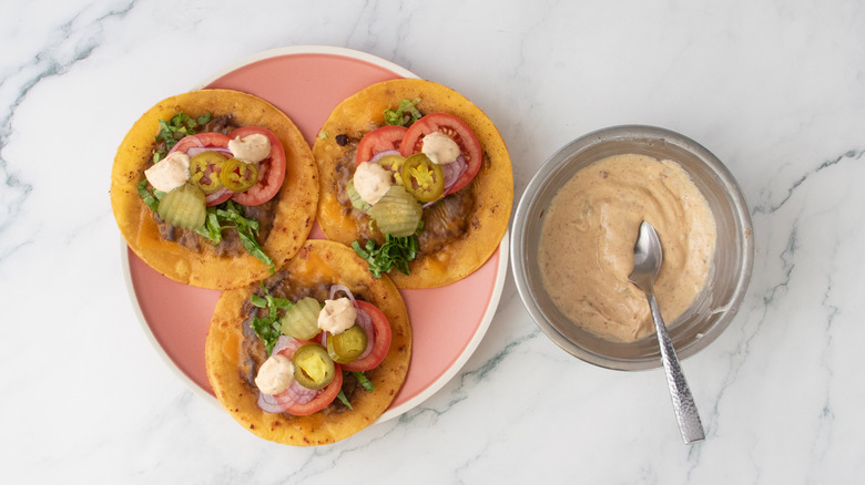 Une assiette de tacos burger garnis de sauce