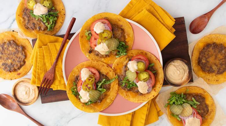 Prise de vue aérienne de plusieurs tacos smash burger avec condiments et garnitures