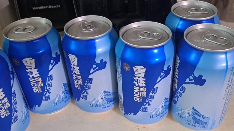 canettes de bière Snow posées sur une surface blanche