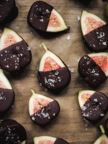 Vue aérienne de figues coupées en deux trempées dans du chocolat noir et saupoudrées de sel marin.