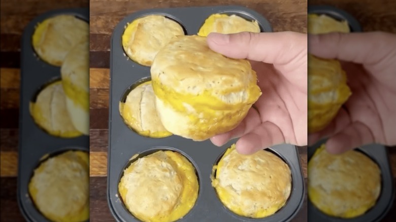 personne tenant un sandwich aux biscuits fraîchement sorti du four