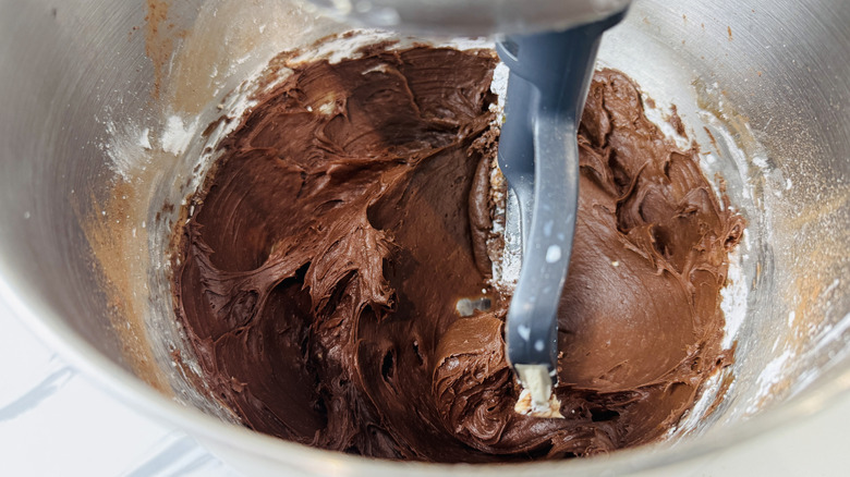 Trempette de pâte à brownie dans le bol du batteur sur socle