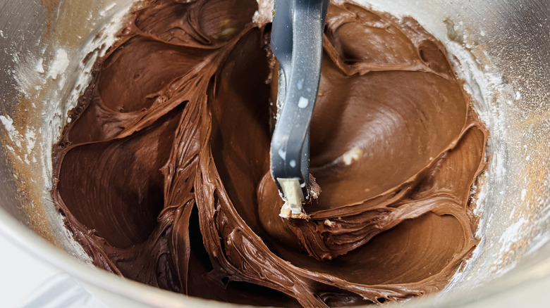 Trempette de pâte à brownie dans le bol du batteur sur socle