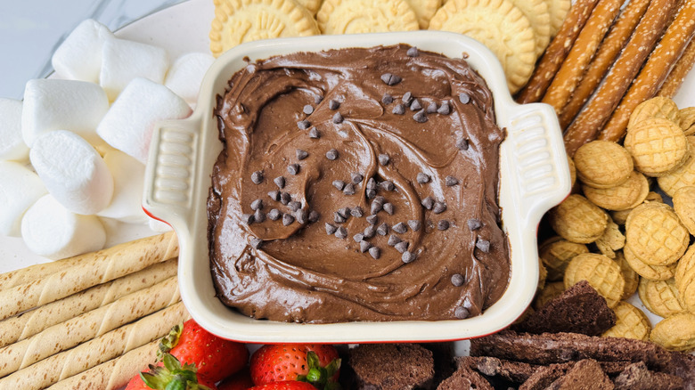 Trempette de pâte à brownie dans un plat de service entouré de diverses trempettes