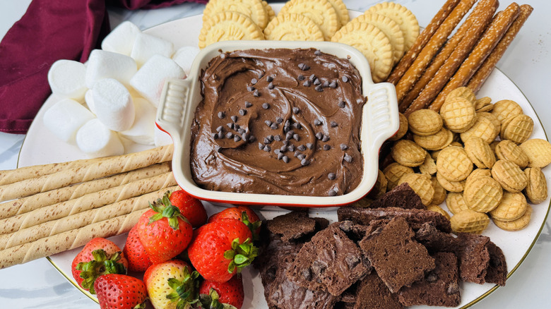 Trempette de pâte à brownie dans un plat de service entouré de diverses trempettes