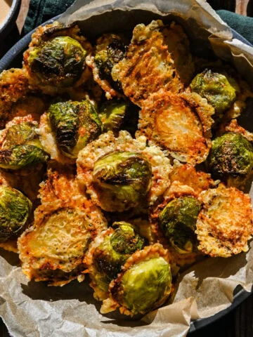 Choux de Bruxelles rôtis croustillants au parmesan dans un bol noir.