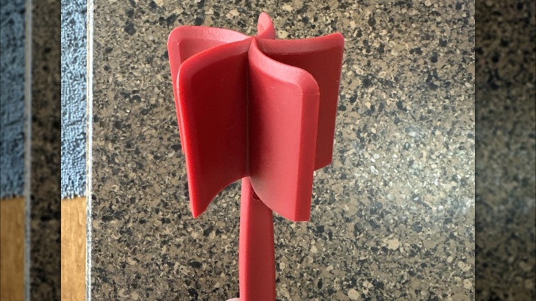 Hachoir à viande rouge placé au-dessus d'un comptoir en granit