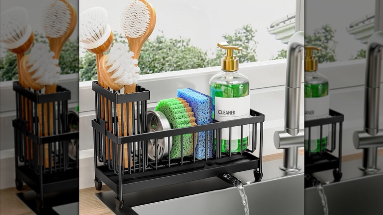Organisateur d'éponges de cuisine noir mat avec éponges, savon, brosses et petit bec versant l'eau dans l'évier