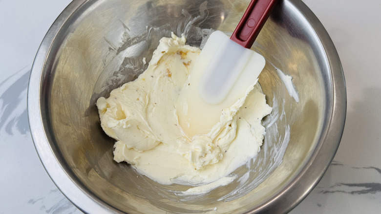 Mélange de fromage à la crème avec une spatule en caoutchouc dans un bol