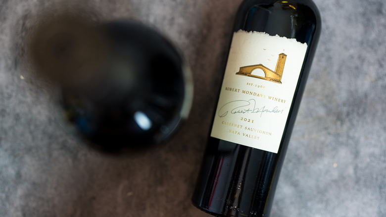 Une bouteille de Cabernet Sauvignon sur une surface grise.