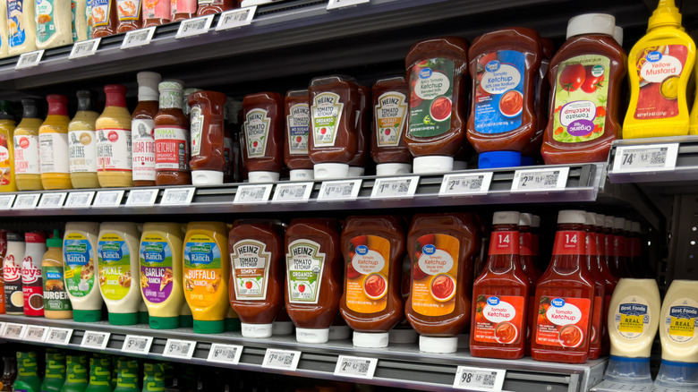Une étagère de magasin remplie de ketchup aux tomates et d'autres condiments
