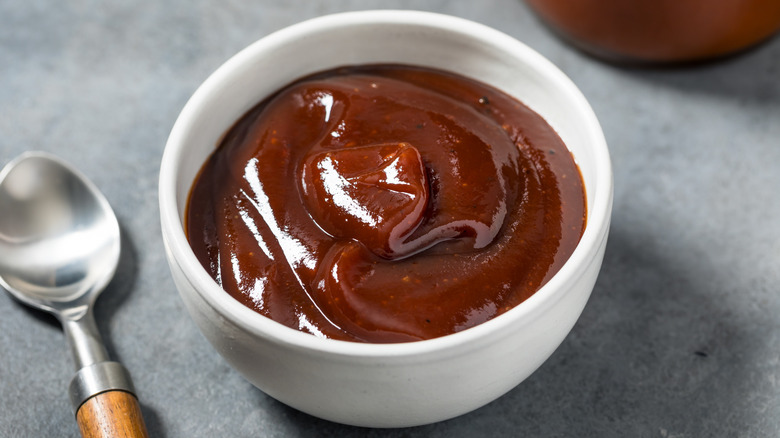 Un petit bol blanc de sauce barbecue.