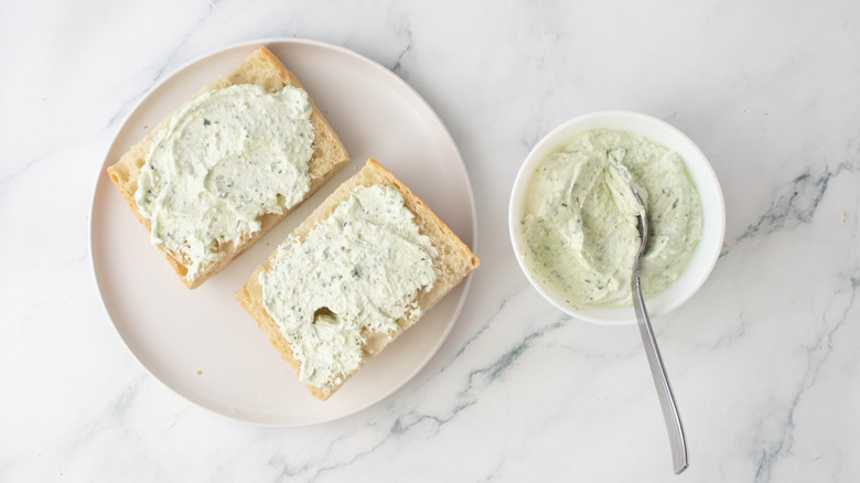 Une portion de pain façon miche tartinée d'un condiment crémeux
