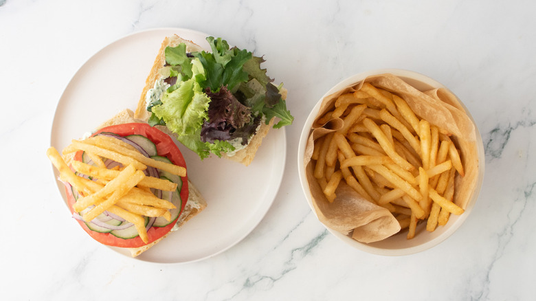 Un burger garni d'un assortiment de légumes et de frites