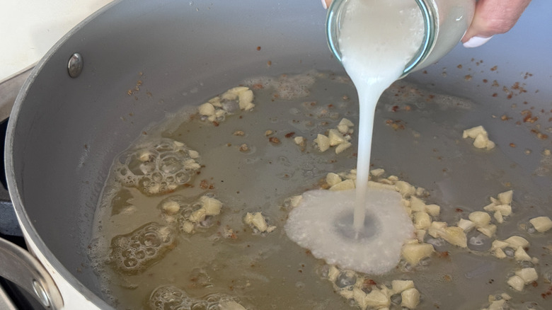 Verser la crème dans la poêle avec l'ail