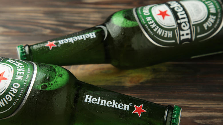 Deux bouteilles de Heineken sur une table en bois.