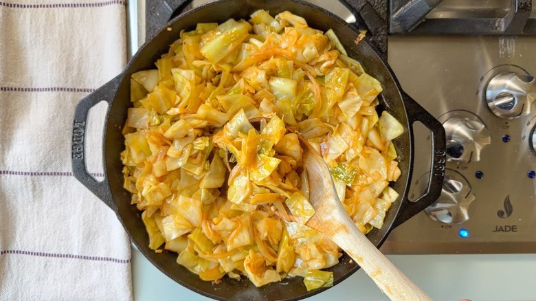 Remuer le chou cowboy dans une poêle sur la cuisinière