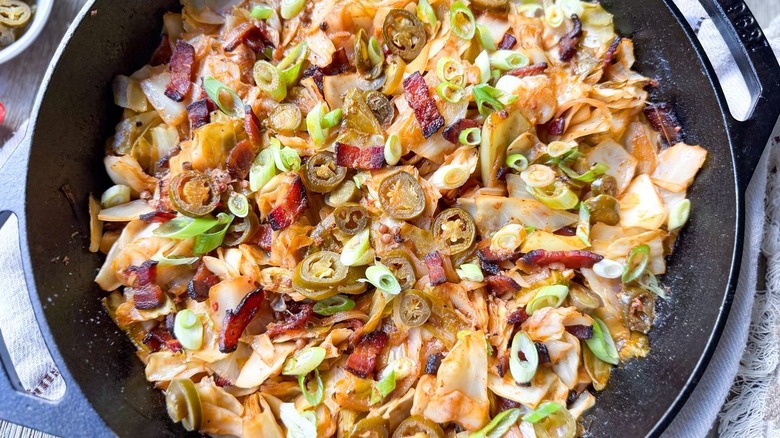 Gros plan de chou cowboy à la poêle avec garniture de jalapeño et d'oignons verts