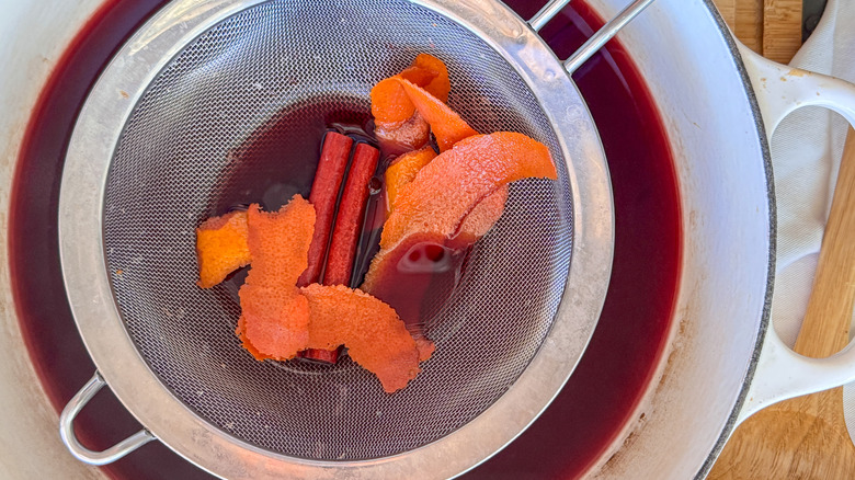 passoire avec zeste d'orange et épices sur vin chaud
